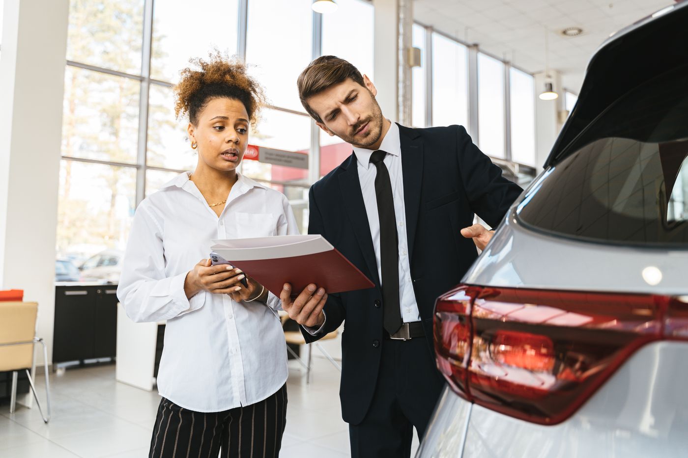 Échange autour d’un véhicule pour préparer un achat automobile